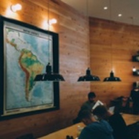Picture of a room with a map on the wall and students sitting at a table